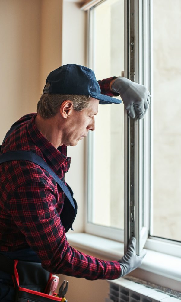 Quality skills. Side view of senior handyman setting new windows